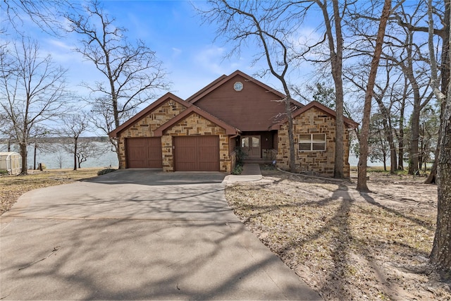 rustic home with a garage, stone siding, and driveway