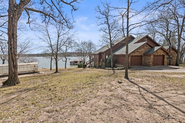 view of yard with a garage and a water view