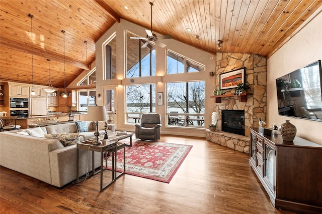 living area with high vaulted ceiling, wood ceiling, wood finished floors, and a fireplace