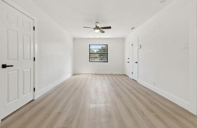 unfurnished room with baseboards, light wood-style flooring, and a ceiling fan