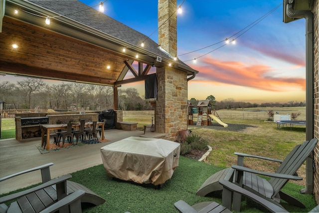 view of patio / terrace featuring a playground, a trampoline, fence, outdoor dining area, and area for grilling