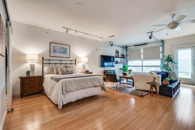 bedroom with rail lighting, visible vents, and light wood-type flooring