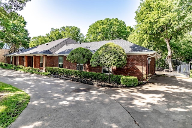 1809 Faulkner Dr, Rowlett, TX 75088 - view of front of home with concrete driveway, brick siding, a gate, and roof with shingles