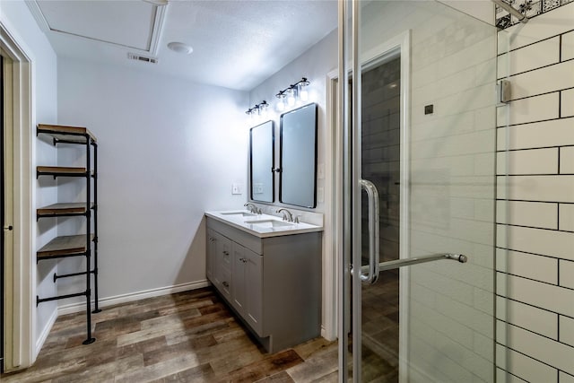 1809 Faulkner Dr, Rowlett, TX 75088 - bathroom featuring double vanity, visible vents, a stall shower, wood finished floors, and baseboards