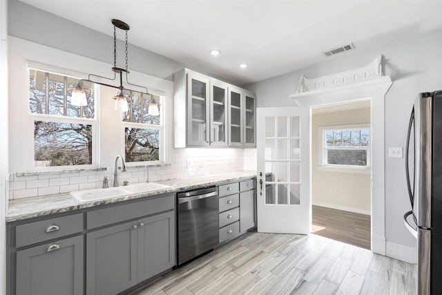 kitchen with a sink, gray cabinetry, visible vents, and stainless steel appliances