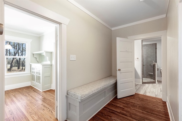 hallway featuring ornamental molding, baseboards, and wood finished floors