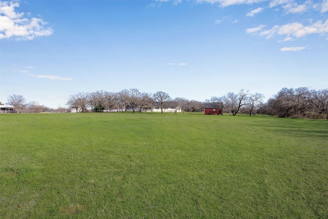 view of yard featuring a rural view and an outdoor structure