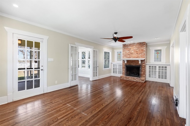 unfurnished living room with dark wood-style floors, a healthy amount of sunlight, a brick fireplace, and ornamental molding