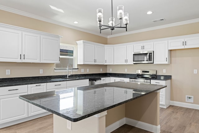 kitchen featuring light wood finished floors, visible vents, appliances with stainless steel finishes, white cabinets, and a sink