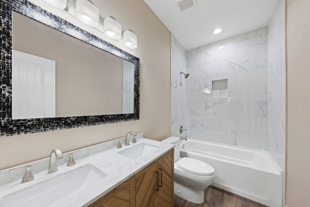 bathroom featuring a sink, visible vents, toilet, and  shower combination