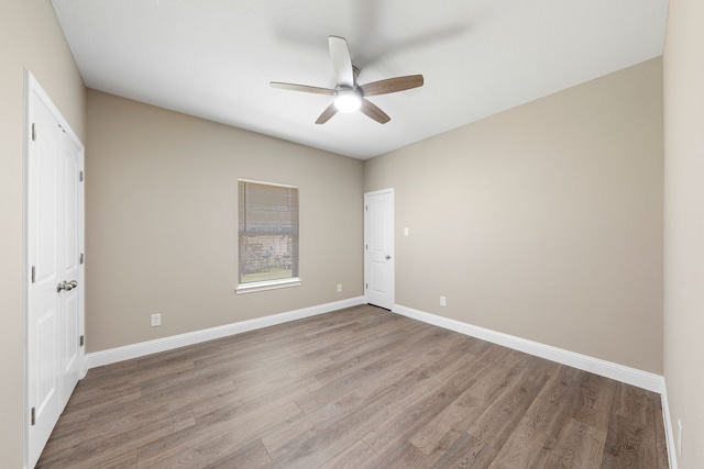 unfurnished room featuring wood finished floors, baseboards, and ceiling fan