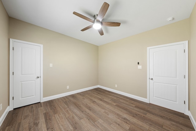 unfurnished room with wood finished floors, baseboards, and ceiling fan