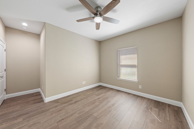 empty room with ceiling fan, light wood-type flooring, and baseboards