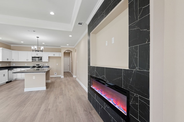 kitchen featuring visible vents, arched walkways, appliances with stainless steel finishes, white cabinetry, and light wood-type flooring