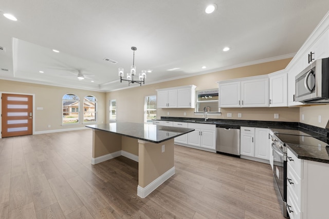 kitchen featuring a tray ceiling, light wood-style flooring, visible vents, and stainless steel appliances