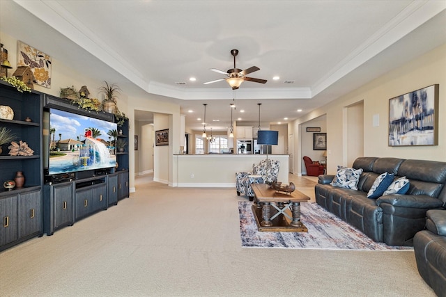 living area featuring crown molding, light carpet, recessed lighting, a raised ceiling, and a ceiling fan