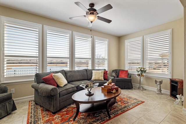 living room featuring light tile patterned flooring, plenty of natural light, a ceiling fan, and baseboards