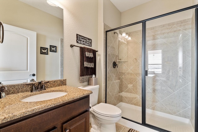 full bathroom with toilet, a stall shower, and vanity