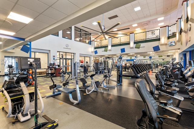 exercise room featuring a drop ceiling and a high ceiling