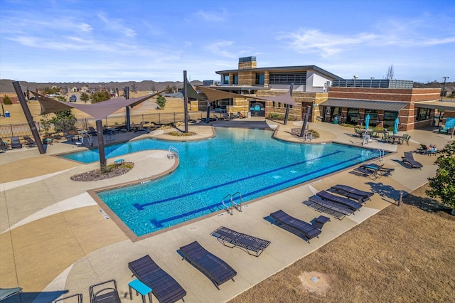 pool with a patio and fence