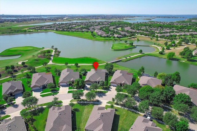 drone / aerial view with view of golf course, a residential view, and a water view