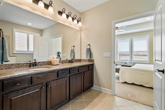 ensuite bathroom featuring tile patterned floors, double vanity, ensuite bath, and a sink