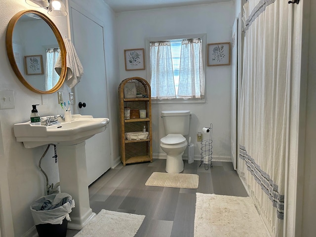 full bathroom with toilet, wood finished floors, and baseboards