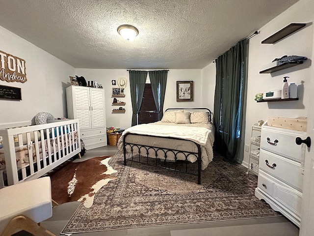 bedroom featuring a textured ceiling and dark wood-style flooring