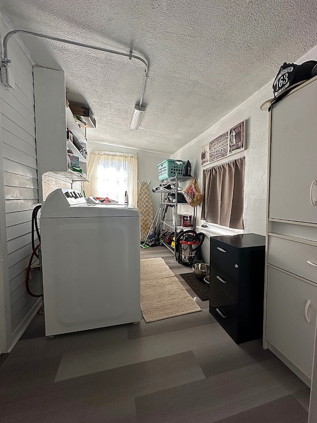 laundry room with laundry area, washer / dryer, a textured ceiling, and wood finished floors