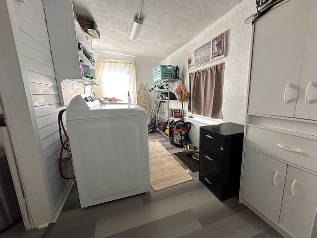 washroom with a textured ceiling, independent washer and dryer, wood finished floors, and a textured wall