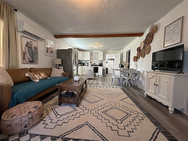 living area with beam ceiling, an AC wall unit, dark wood-style floors, and a textured ceiling