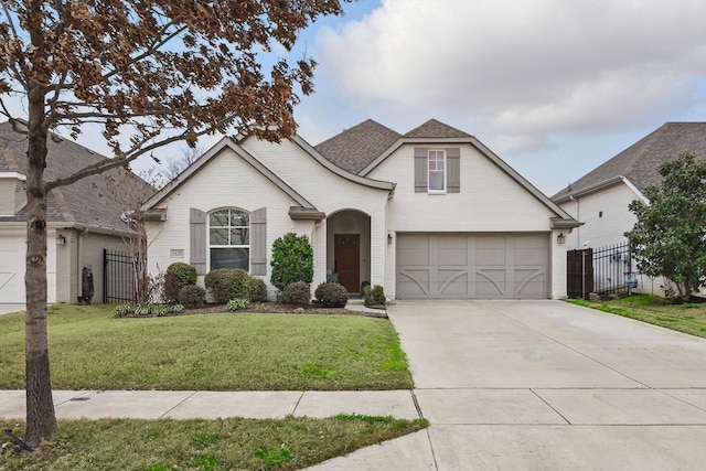 view of front of house with a front yard, fence, concrete driveway, a garage, and brick siding