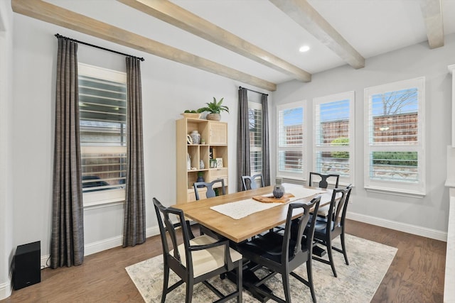 dining area with baseboards, plenty of natural light, beam ceiling, and wood finished floors