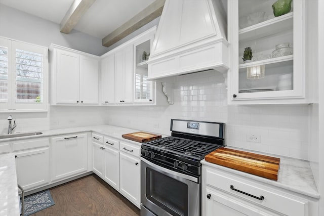 kitchen featuring premium range hood, a sink, stainless steel gas range, white cabinets, and dark wood-style flooring