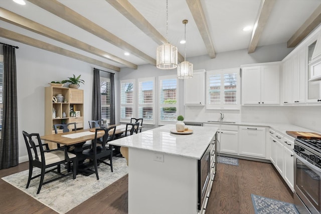 kitchen with dark wood finished floors, white cabinets, stainless steel gas range, and a sink