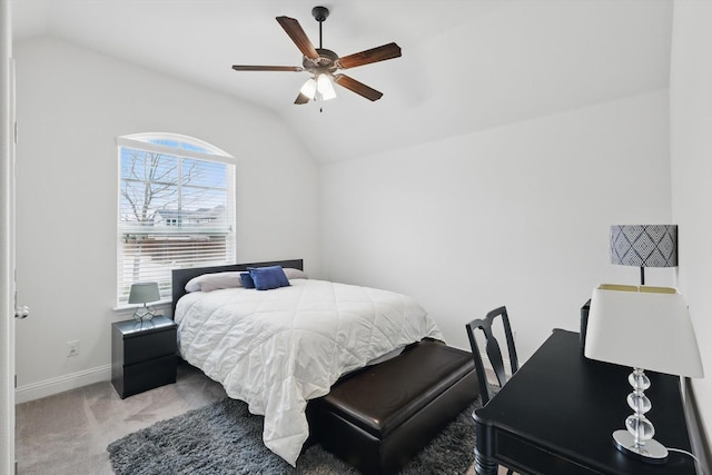 carpeted bedroom featuring baseboards, lofted ceiling, and a ceiling fan