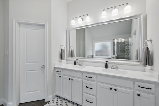 full bath with double vanity, an enclosed shower, and a sink