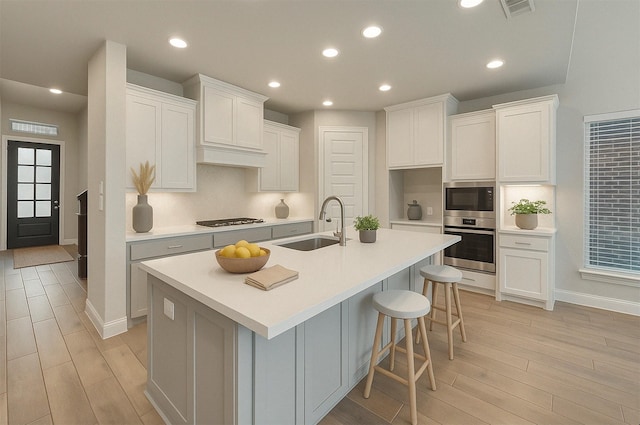 kitchen featuring light wood-type flooring, visible vents, a sink, and appliances with stainless steel finishes