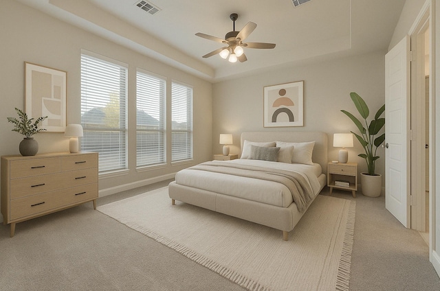 bedroom with a tray ceiling, visible vents, and light colored carpet