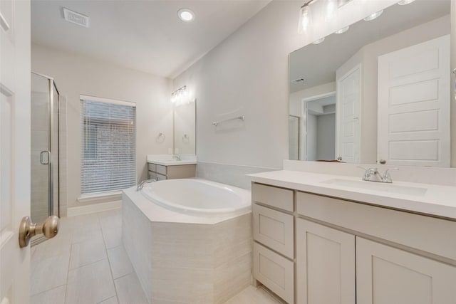 bathroom featuring tile patterned flooring, visible vents, a garden tub, a stall shower, and a sink