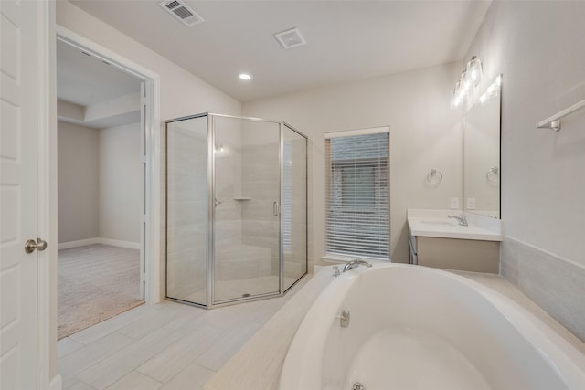 full bathroom featuring vanity, a bath, visible vents, and a stall shower