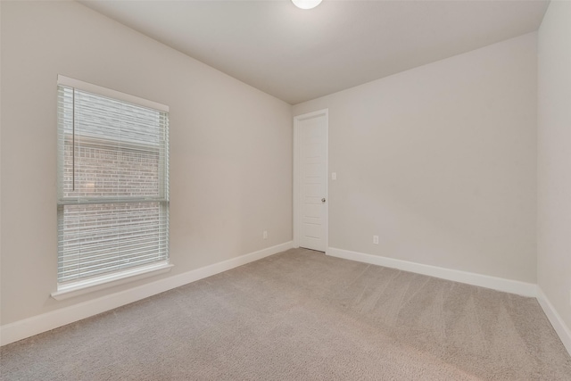 unfurnished room with light colored carpet, a healthy amount of sunlight, and baseboards