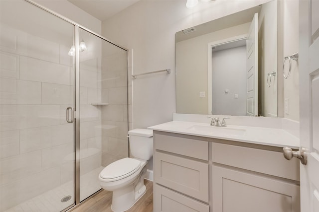 full bathroom featuring visible vents, toilet, a stall shower, wood finished floors, and vanity