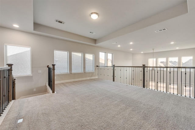 carpeted spare room featuring plenty of natural light, recessed lighting, and visible vents