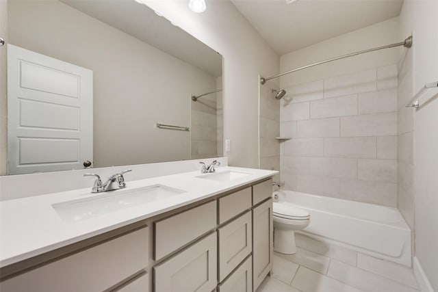 full bathroom with double vanity, tile patterned floors, toilet, and a sink