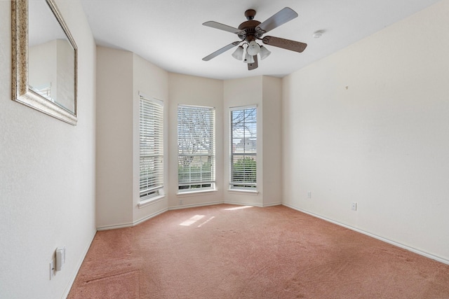 carpeted spare room with baseboards and a ceiling fan