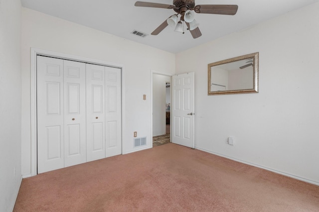 unfurnished bedroom featuring a closet, visible vents, a ceiling fan, and carpet