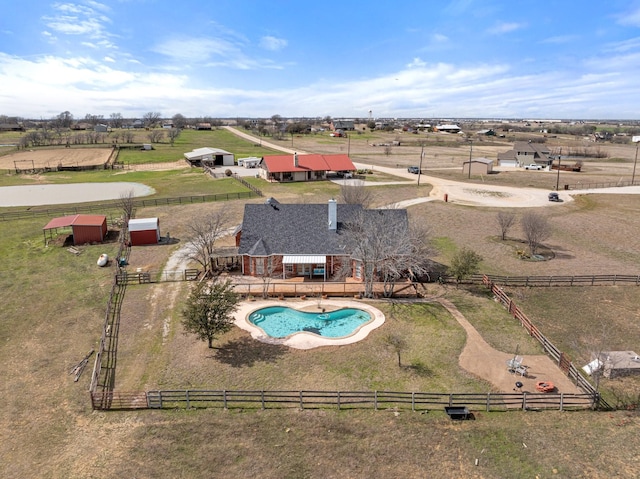 view of pool with a rural view and fence