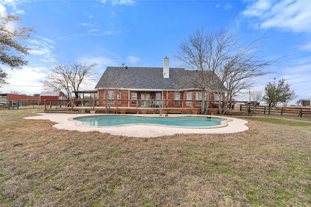 view of swimming pool featuring a yard, a wooden deck, and fence