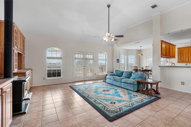 living room featuring light tile patterned floors, a ceiling fan, baseboards, visible vents, and high vaulted ceiling